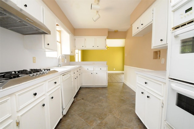 kitchen featuring a sink, white appliances, light countertops, and under cabinet range hood