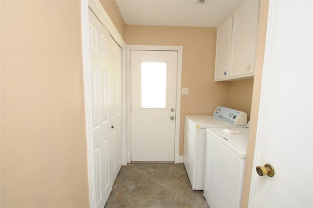 clothes washing area featuring washing machine and dryer, cabinet space, baseboards, and visible vents