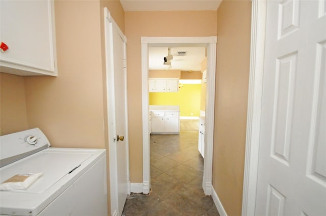 washroom featuring dark tile patterned floors, cabinet space, baseboards, visible vents, and washer / clothes dryer
