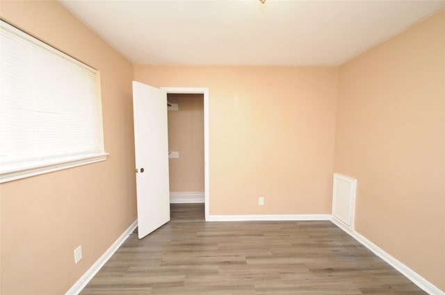 empty room featuring wood finished floors and baseboards