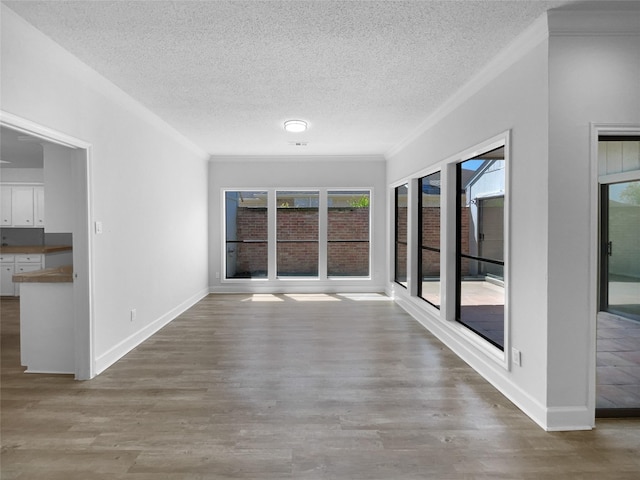 202 Essex Pl, Stafford, TX 77477 - interior space with baseboards, a textured ceiling, crown molding, and wood finished floors