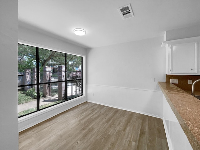 202 Essex Pl, Stafford, TX 77477 - unfurnished dining area featuring wood finished floors, baseboards, and visible vents