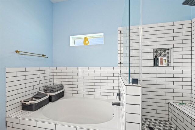 full bathroom with a tile shower and a bath