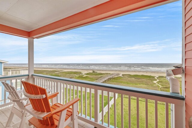 balcony featuring a water view and a view of the beach