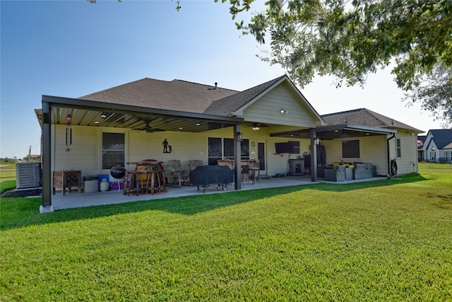 back of house featuring a patio, a shingled roof, a ceiling fan, and a lawn