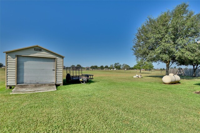 view of yard with fence and an outdoor structure