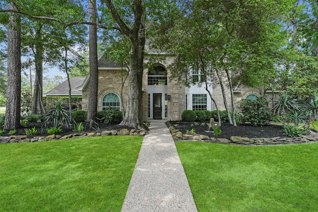 2023 Forest Garden Dr, Kingwood, TX 77345 - view of front of home with a front yard, brick siding, and roof with shingles