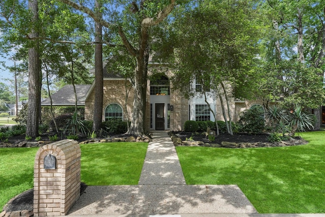 2023 Forest Garden Dr, Kingwood, TX 77345 - view of front of home featuring brick siding and a front lawn