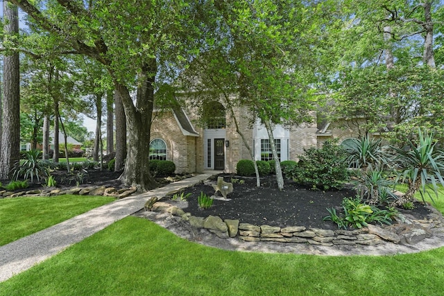 2023 Forest Garden Dr, Kingwood, TX 77345 - view of property hidden behind natural elements with a front lawn and brick siding