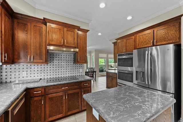 2023 Forest Garden Dr, Kingwood, TX 77345 - kitchen with appliances with stainless steel finishes, under cabinet range hood, crown molding, tasteful backsplash, and recessed lighting