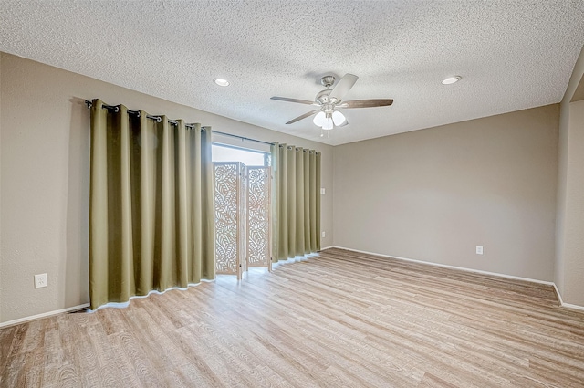 unfurnished room with baseboards, light wood finished floors, a textured ceiling, and a ceiling fan