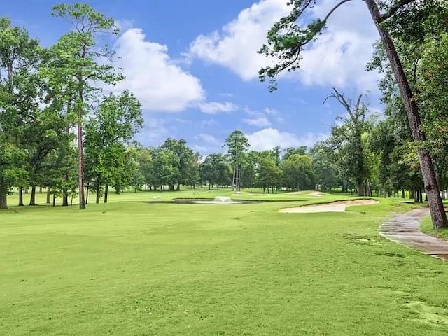 view of home's community featuring golf course view and a yard