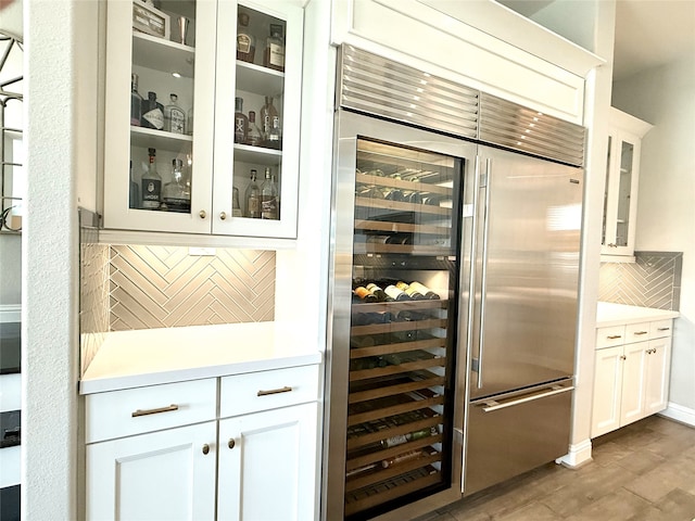 bar with decorative backsplash and built in refrigerator