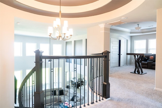 hallway featuring a chandelier, an upstairs landing, a raised ceiling, visible vents, and carpet