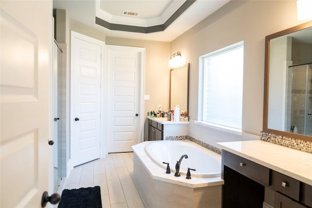 full bathroom with visible vents, a shower stall, a bath, and vanity
