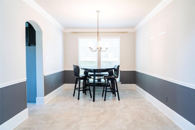 dining space with ornamental molding, arched walkways, a notable chandelier, and baseboards