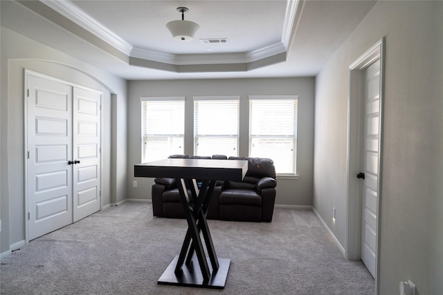 office area with a raised ceiling, visible vents, crown molding, and carpet flooring