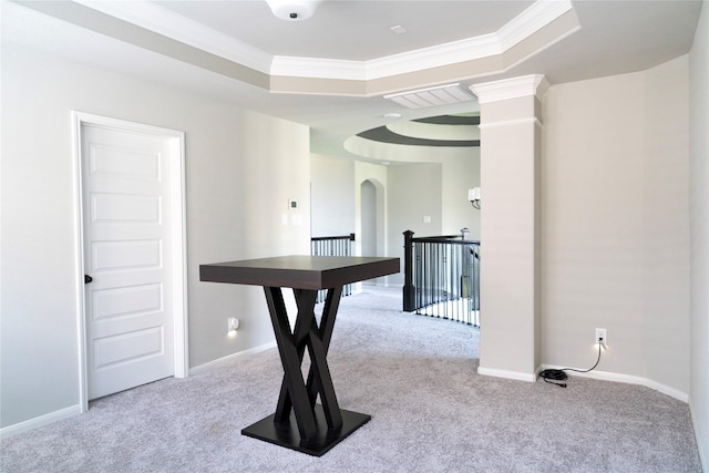 interior space featuring a raised ceiling, crown molding, baseboards, arched walkways, and carpet floors