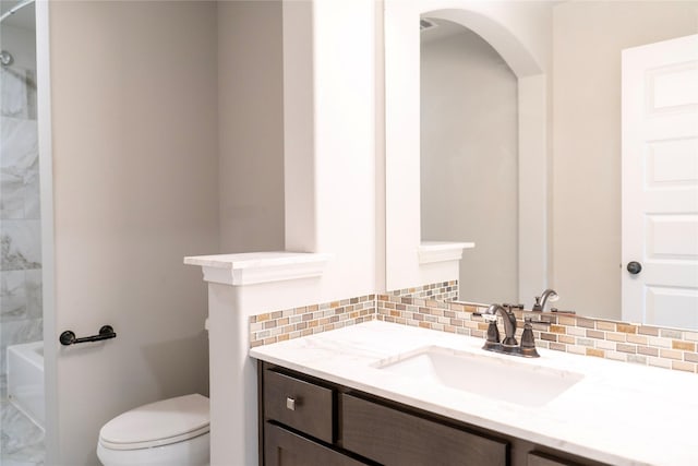 bathroom featuring toilet, vanity, and decorative backsplash