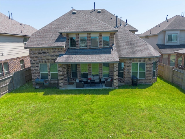 rear view of property with roof with shingles, brick siding, and a fenced backyard