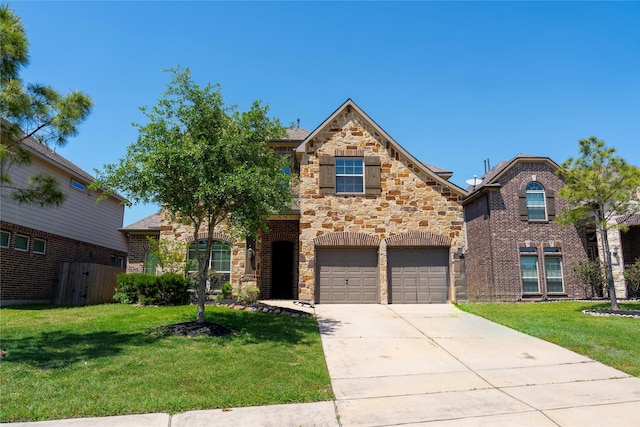 traditional-style house with concrete driveway, a front yard, an attached garage, and stone siding