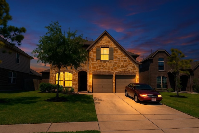traditional home featuring concrete driveway, a yard, an attached garage, and stone siding