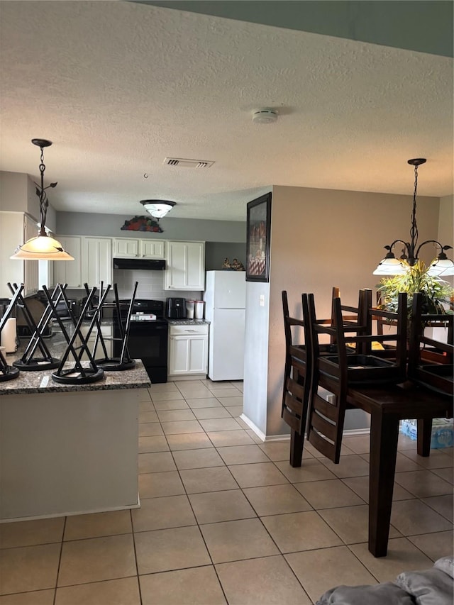 22223 Springgate Dr, Spring, TX 77373 - dining area featuring visible vents, a textured ceiling, and light tile patterned floors