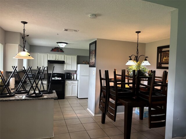22223 Springgate Dr, Spring, TX 77373 - dining space featuring light tile patterned floors, a chandelier, a textured ceiling, and visible vents
