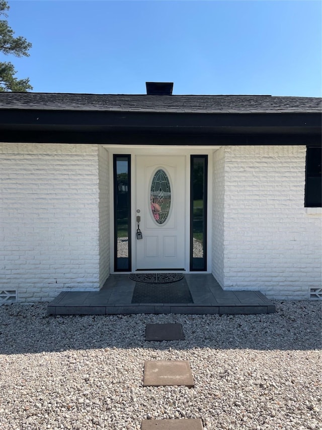 view of exterior entry featuring brick siding