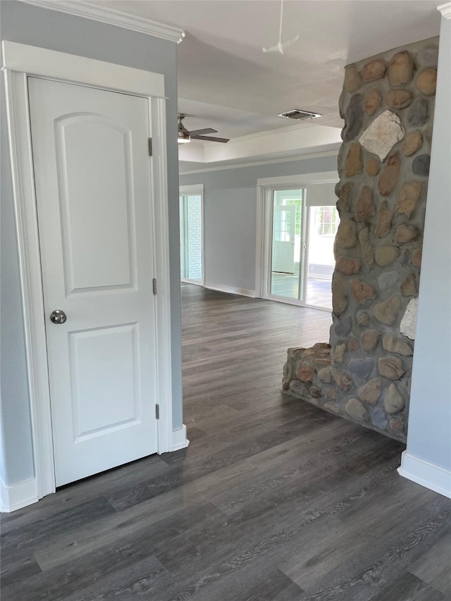 hallway featuring dark wood-style flooring, baseboards, ornamental molding, and visible vents