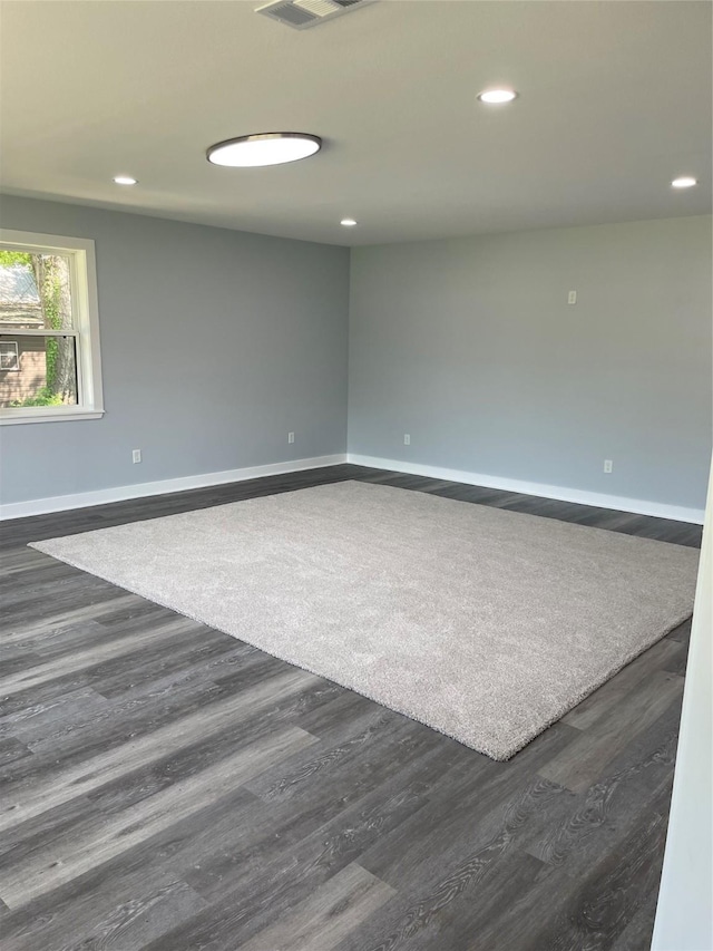 spare room with recessed lighting, visible vents, baseboards, and dark wood finished floors