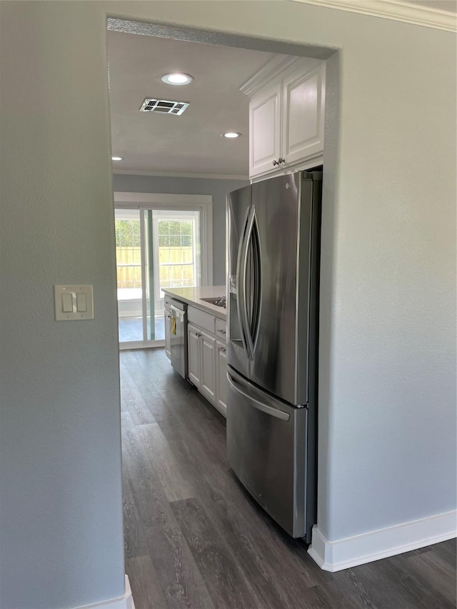 kitchen featuring crown molding, white cabinets, visible vents, dark wood finished floors, and appliances with stainless steel finishes