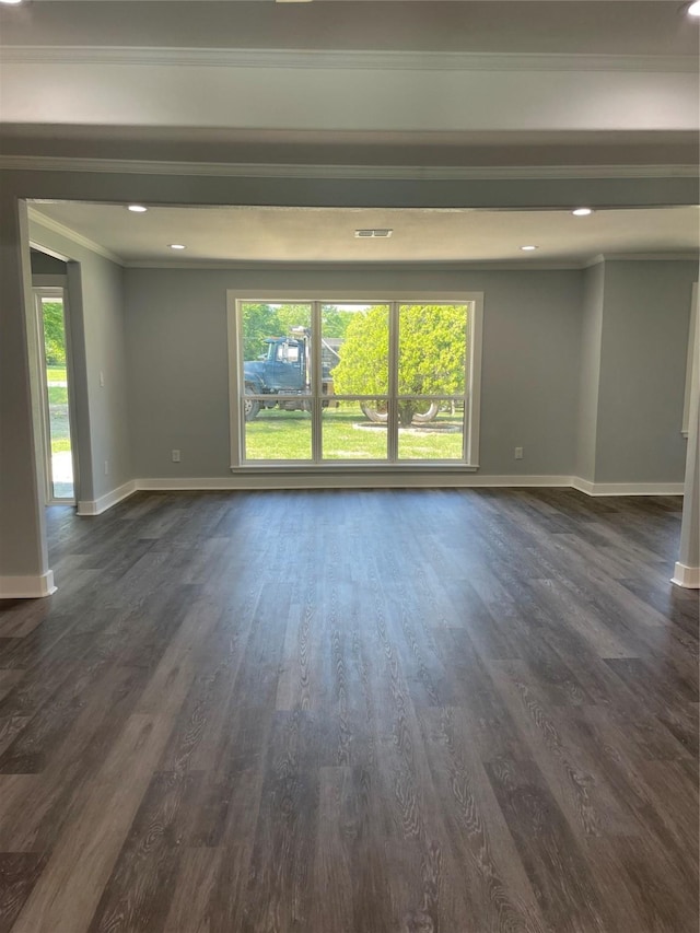 spare room with crown molding, baseboards, and a wealth of natural light