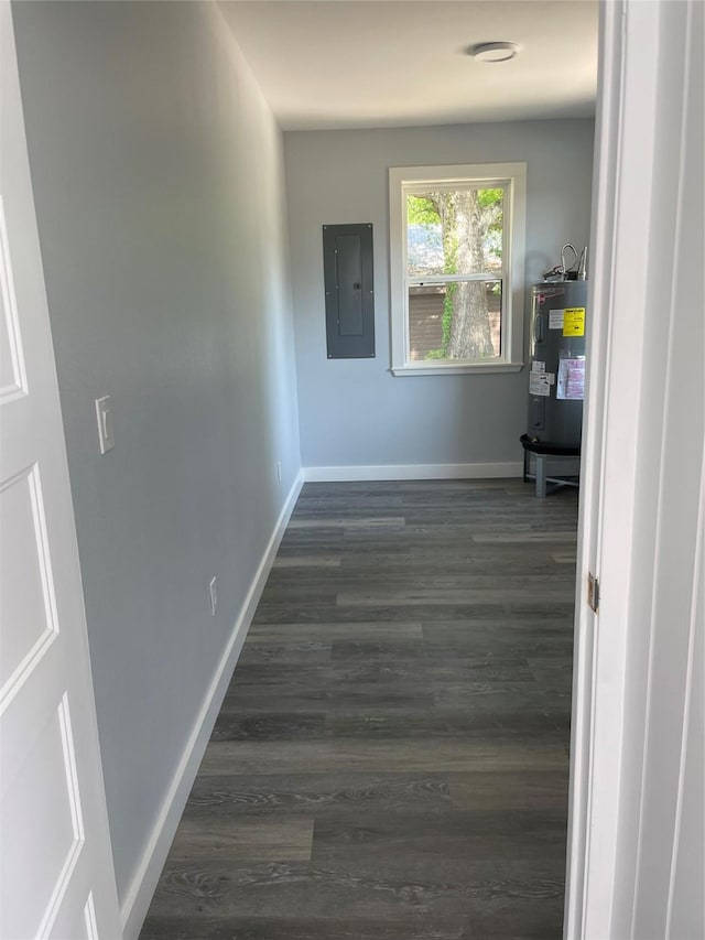hallway featuring water heater, baseboards, electric panel, and dark wood-type flooring