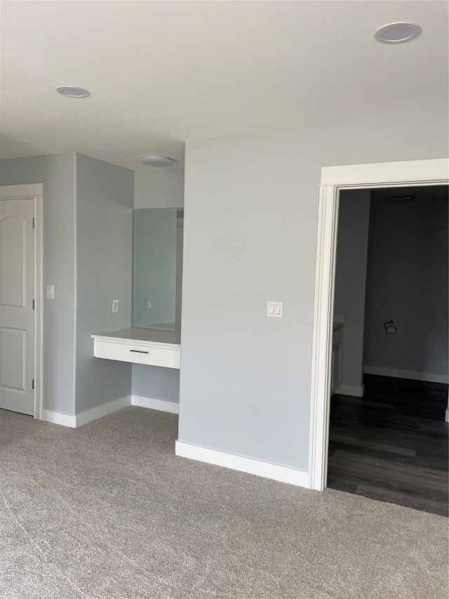 carpeted spare room featuring baseboards