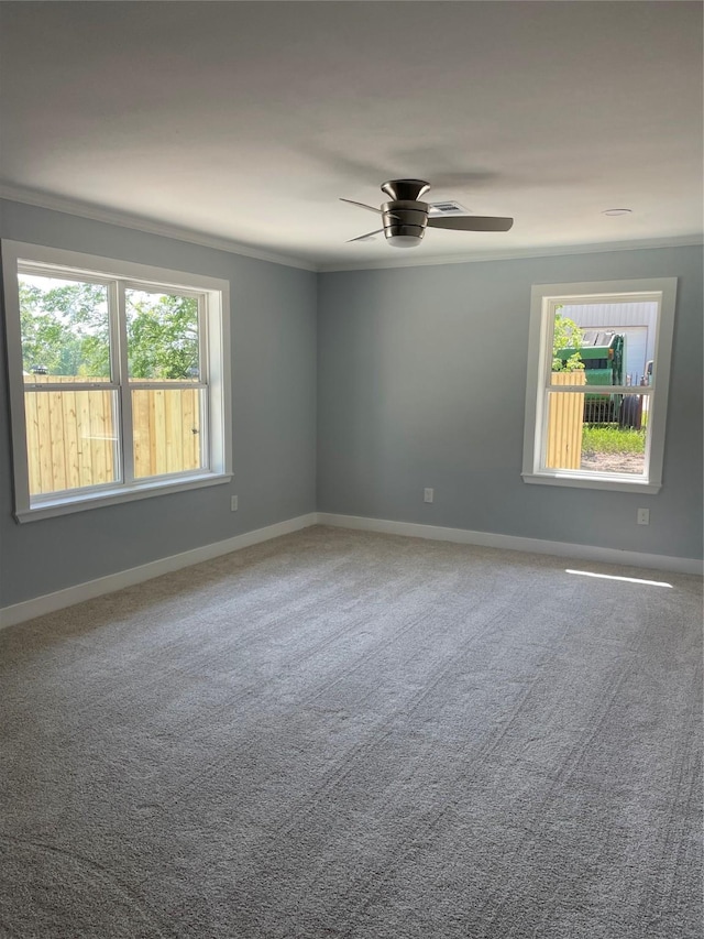 unfurnished room with a wealth of natural light, baseboards, crown molding, and a ceiling fan