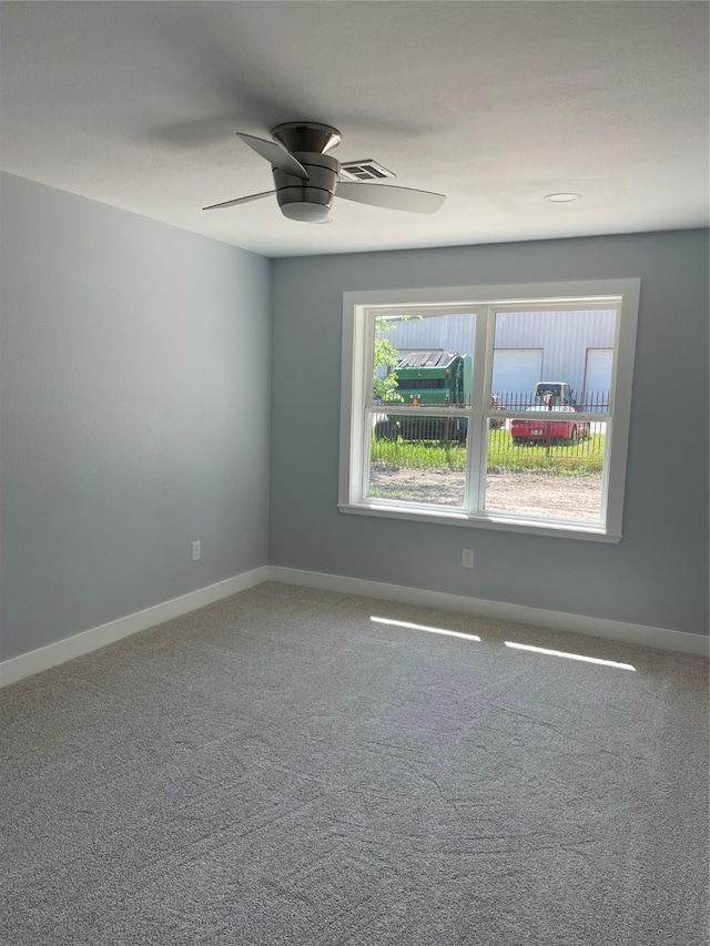 unfurnished room with visible vents, baseboards, a ceiling fan, and carpet