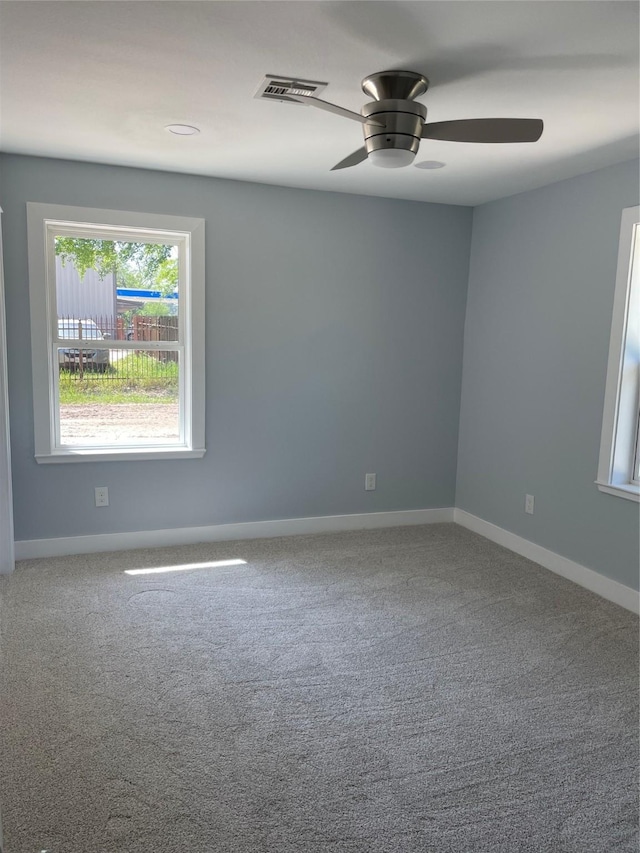 empty room featuring visible vents, ceiling fan, carpet, and baseboards