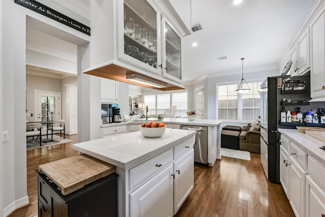 1301 Ketch Ct, League City, TX 77573 - kitchen with dishwasher, a kitchen island, a peninsula, white cabinetry, and crown molding