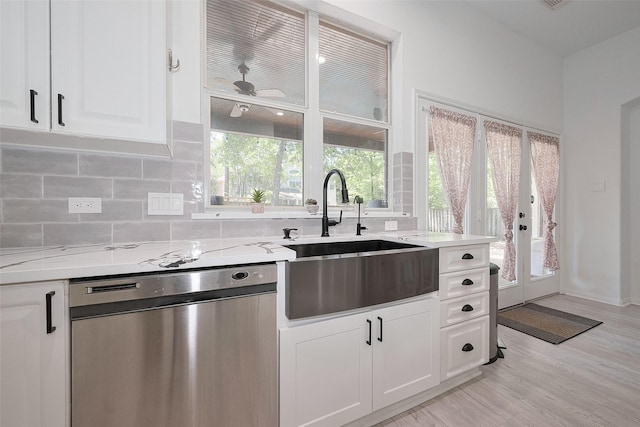 70 N Altwood Cir, The Woodlands, TX 77382 - kitchen featuring dishwasher, a sink, white cabinetry, backsplash, and light wood-style flooring