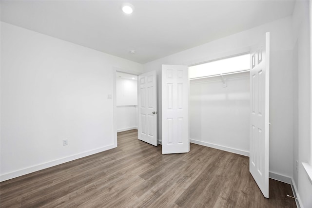 unfurnished bedroom featuring a closet, baseboards, and wood finished floors