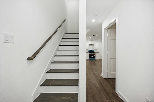 staircase with recessed lighting and wood finished floors
