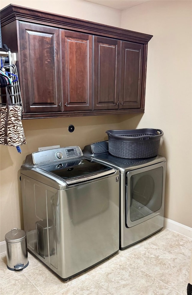 34315 E Short Leaf Pine Ct, Pinehurst, TX 77362 - washroom with cabinet space, washer and dryer, baseboards, and light tile patterned flooring