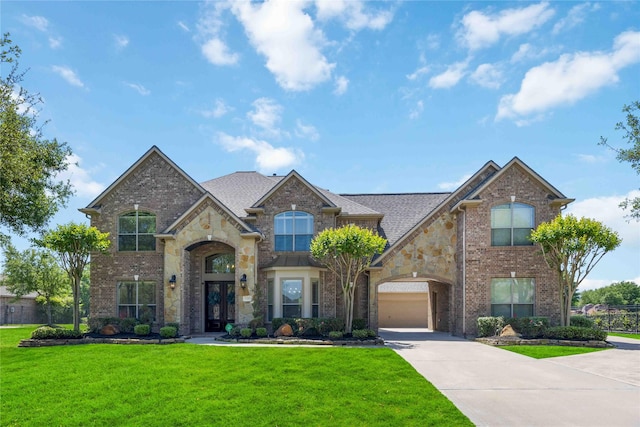 21207 Fairhaven Creek Dr, Cypress, TX 77433 - view of front facade featuring french doors, stone siding, concrete driveway, brick siding, and a front yard