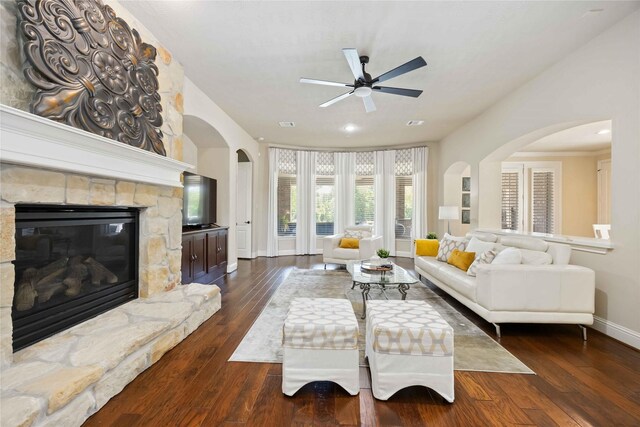 21207 Fairhaven Creek Dr, Cypress, TX 77433 - living area with arched walkways, baseboards, a ceiling fan, a fireplace, and dark wood-type flooring