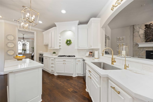 21207 Fairhaven Creek Dr, Cypress, TX 77433 - kitchen featuring gas cooktop, arched walkways, a sink, a chandelier, and ornamental molding