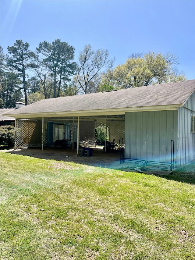 view of side of home with a lawn, a carport, and board and batten siding