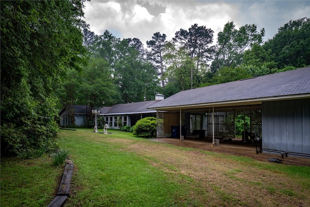 back of property with board and batten siding, a patio area, and a lawn