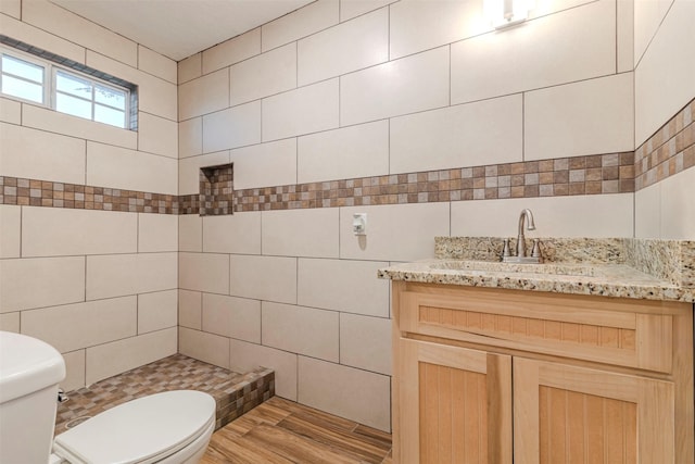1189 Fm 935, Lott, TX 76656 - bathroom featuring tile walls, toilet, vanity, and wood finished floors