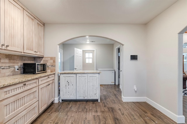 1189 Fm 935, Lott, TX 76656 - kitchen with stainless steel microwave, baseboards, backsplash, dark wood finished floors, and arched walkways